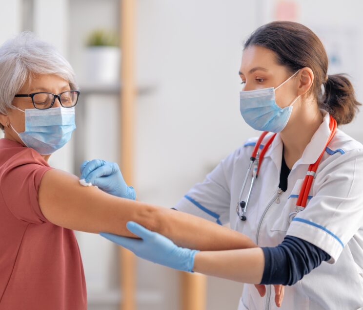 Doctor giving a senior woman a vaccination