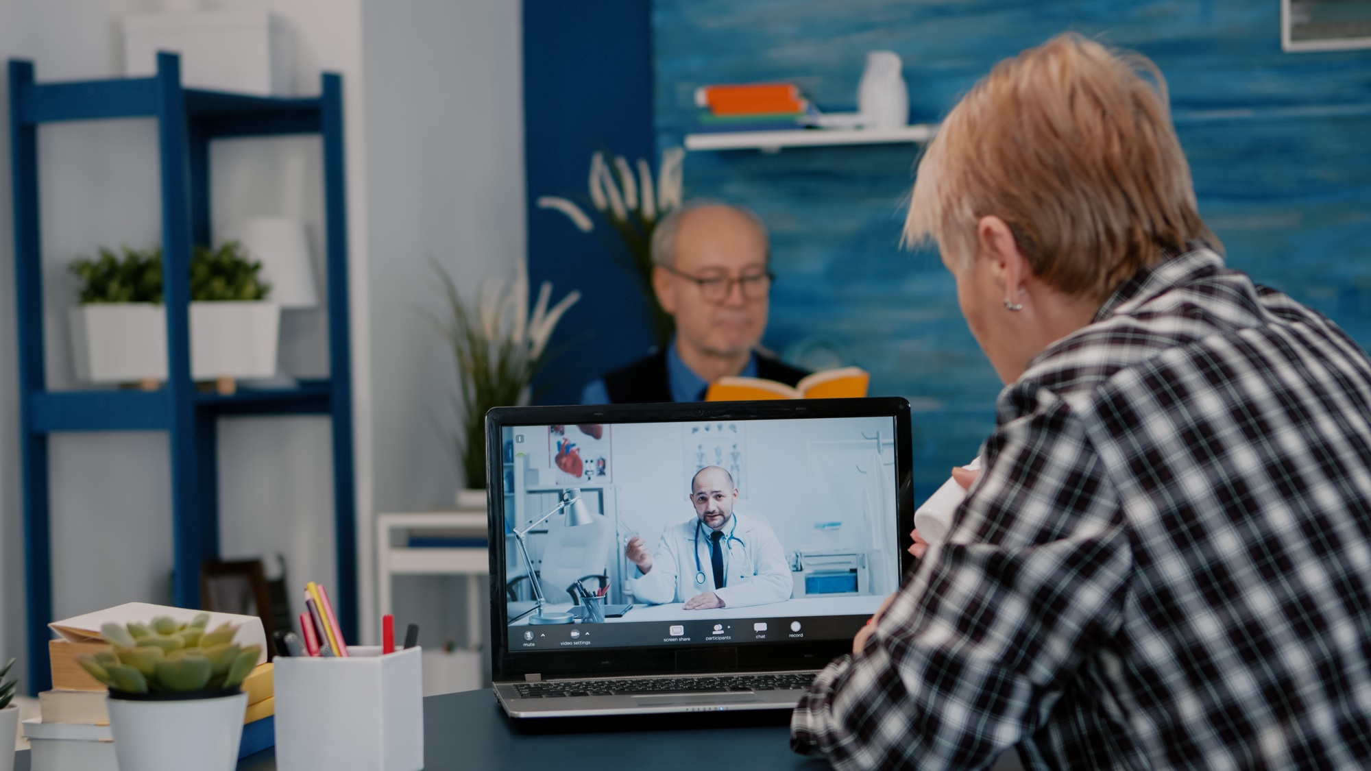 Young male doctor talking to senior female patient by tele medicine online